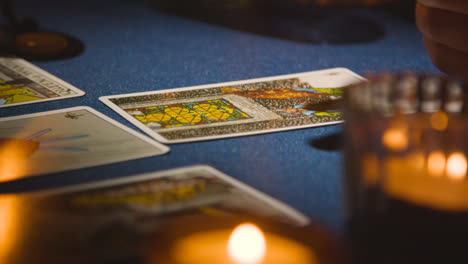 Nahaufnahme-Einer-Frau,-Die-Am-Tisch-Bei-Kerzenschein-Tarotkarten-Liest-5